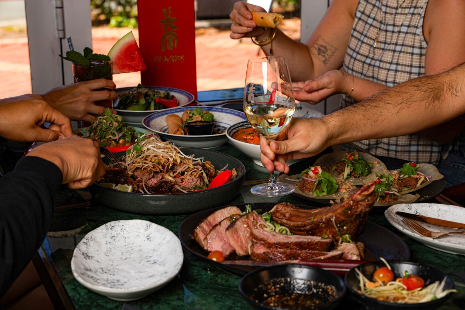 Friends sharing plates by the open doors of the dining room