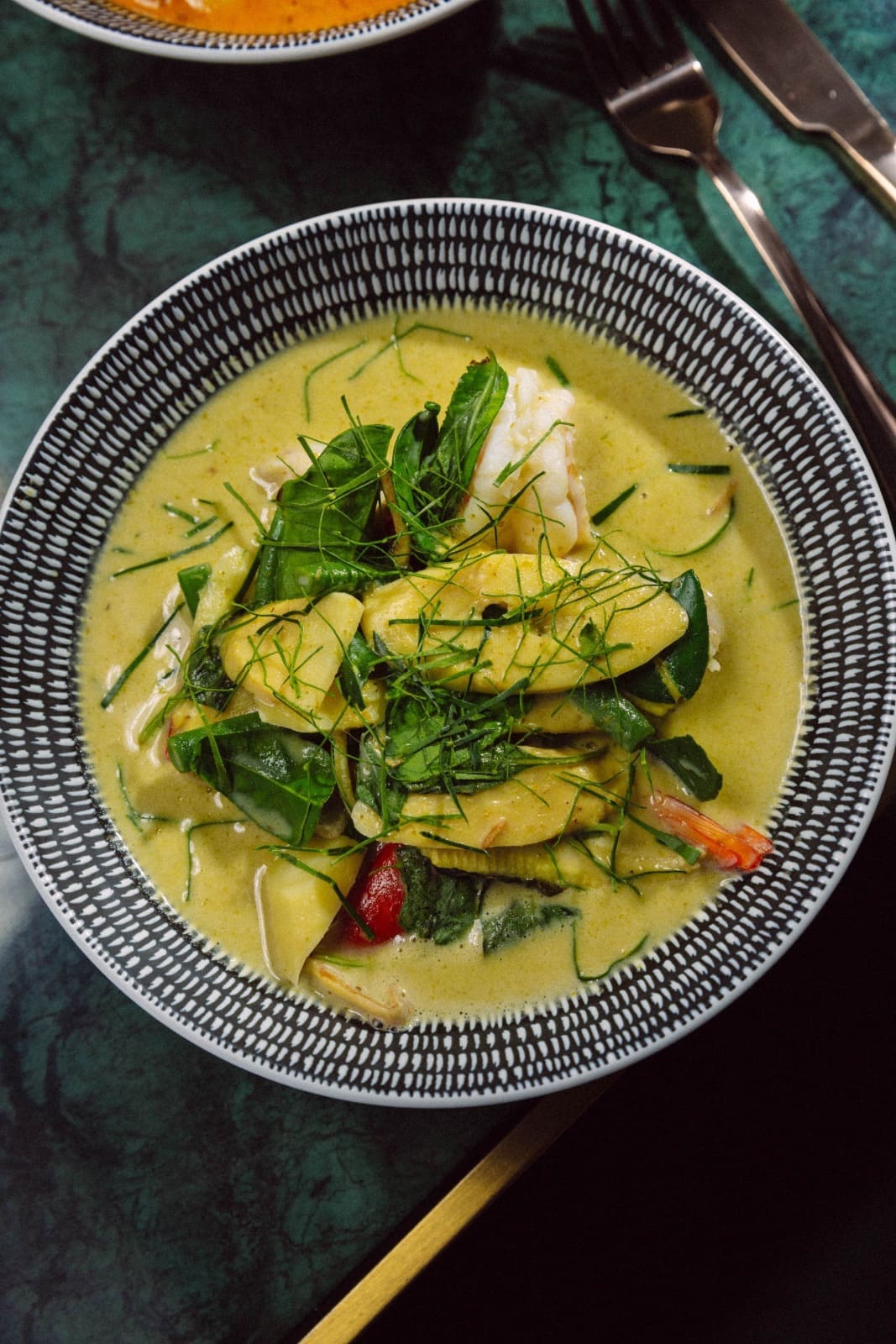 Green curry of prawns with Thai basil in a patterned bowl